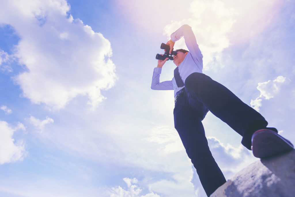 pracownik firmy patrzący przez lornetkę - symbol osoby, która zastanawia się jak znaleźć i wybrać dobrego tłumacza