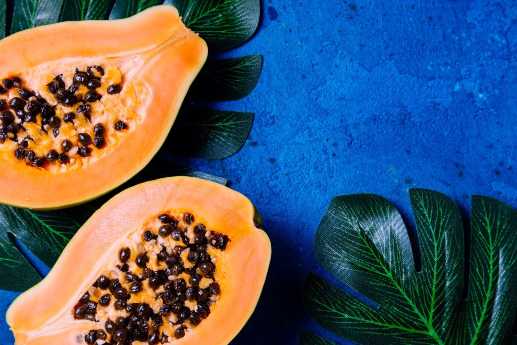 przekrojona papaja na niebieskim tle