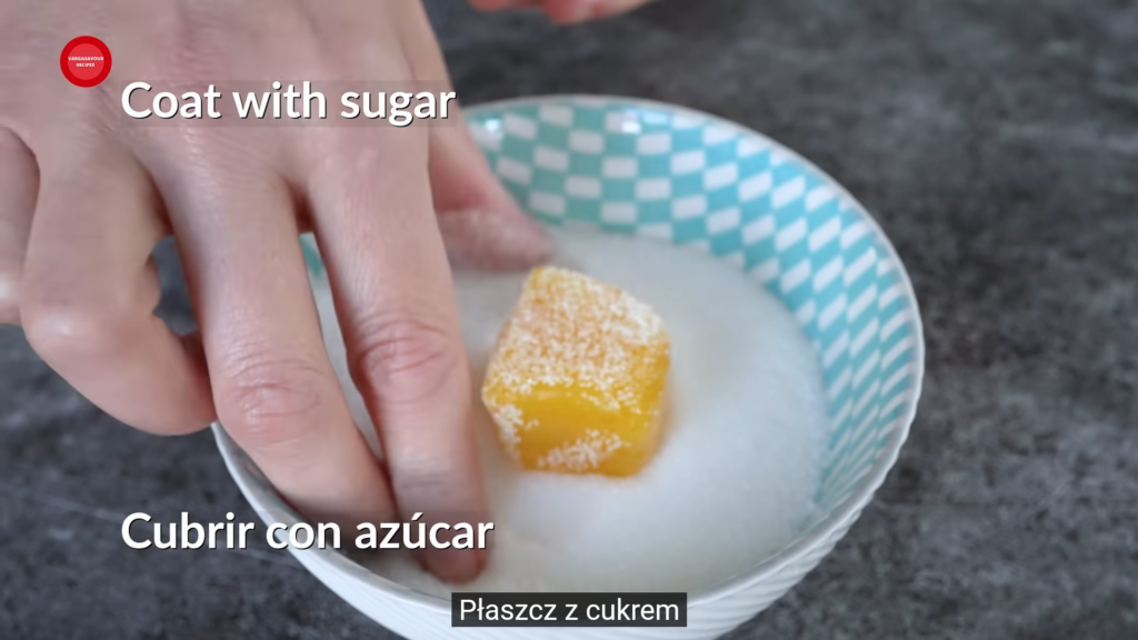 ręka obtaczająca w cukrze słodycze