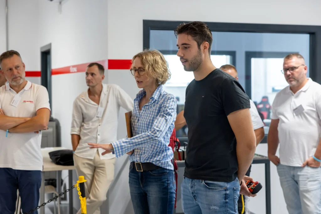 Formazione tecnica in produzione durante installazione di macchinari industriali, con spiegazioni operative sul posto.